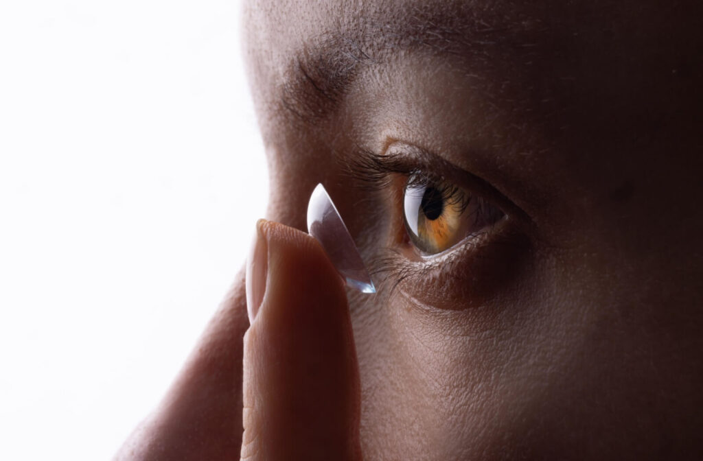 Close-up of a person applying a contact lens, trying contact lenses to help with their astigmatism.