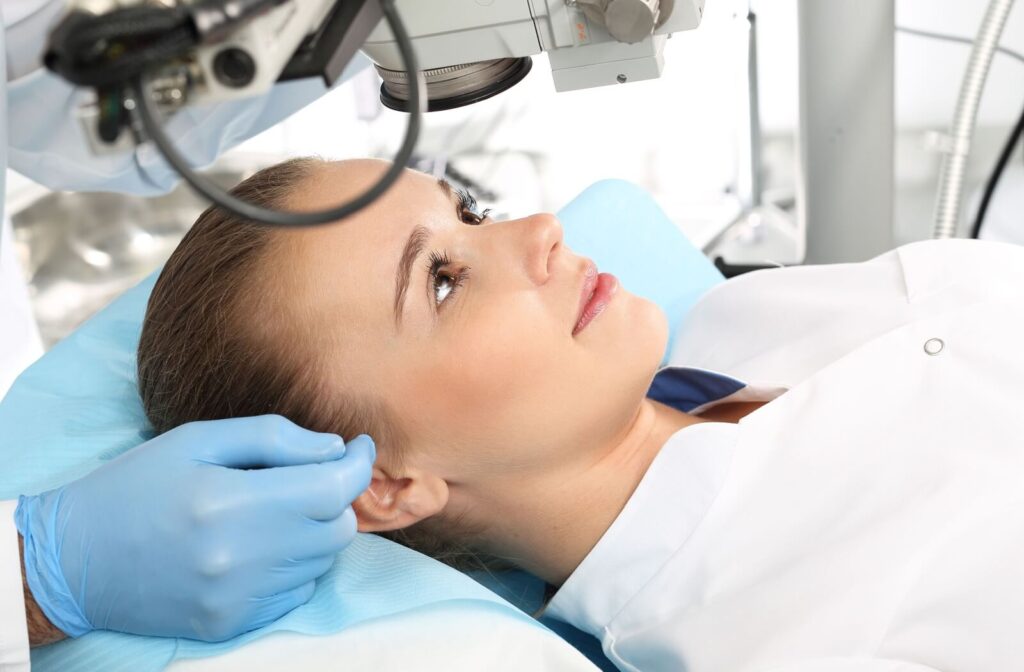 Patient lying under an eye exam microscope, being evaluated for possible vision correction or astigmatism-related treatment.